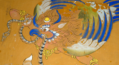 Mural of a Garuda painted in traditional Bhutanese style on a wall in Wangdichholing Dzong. It has a snake, naga, in its beak.