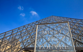 The Louvre Museum entrance sign at the Glass Pyramid, Paris