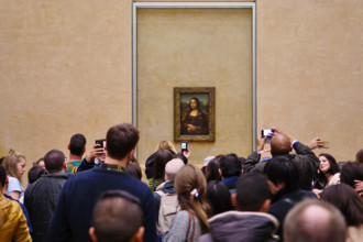 Visitors take selfie pictures on their phones in front of the Mona Lisa (La Joconde) painting by Leonardo da Vinci in the Louvre