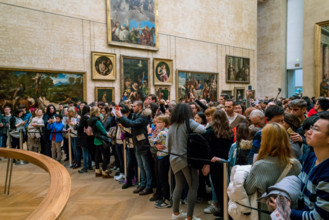 PARIS, FRANCE - FEBRUARY 15, 2018: Visitors take photo of Leonardo DaVinci's "Mona Lisa" at the Louvre Museum