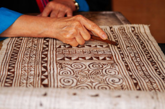 APR 4, 2018 Luang Prabang, Laos - Hilltribe Laotian woman working on Batik fabric painting. Culture tourism at Ock Pop Tok handicraft center