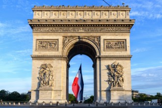 France, Paris, Champs ELysees, 2022-07-14. Early in the morning, the French flag is installed on the Arc de Triomphe for the July 14 parade. Photograp