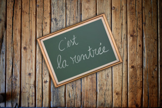 Wooden textured table from above and back to school concept in french