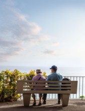 Rear view of senior couple sitting and look at the endless horizon