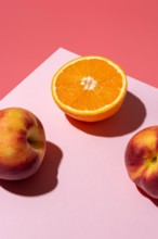 Orange fruit with peaches on bright background. Minimal food concept.
