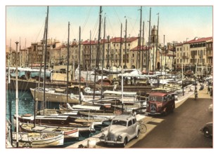 ST.TROPEZ Vintage 1950’s 1960's View of the harbour with fishing and sailing boats moored with French Citroen Van and Peugeot Motorcar parked, cafes and restaurants behind. Côte d’Azur South of France...