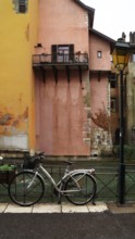 a classic street lantern next to a bicycle in front of the river against the backdrop of a traditional building, Annesy, France
