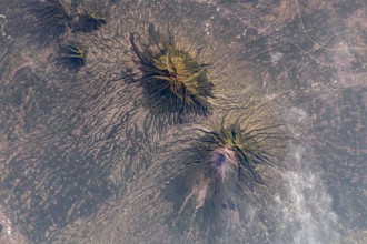 The Earth seen from the International Space Station: A smoking Mount Merapi (lower) and Mount Merbabu (top), Java, Indonesia, 10 May 2021. Mount Merapi is a highly active volcano in Central Java.  An ...