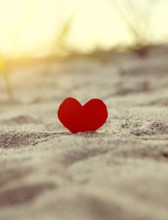Toned Photo of the Red Heart in the Sand at the Evening Beach