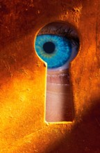 Eye peering through a keyhole