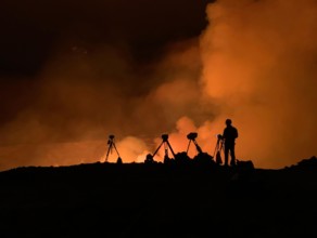 An Hawaiian Volcano Observatory geologist monitoring K?lauea ?volcano is erupting. Hawaii, USA. With the summit eruption continuing through the night, HVO scientists monitor the eruption for changes i...