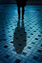 mysterious woman in black coat and boots with shadow