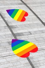 Rainbow hearts on a grey stone pavement