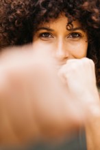 Portrait of a young woman in a boxing stance showcasing strength, determination, and focus during an outdoor training session.