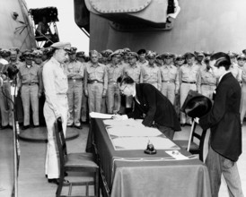 Japanese Foreign Minister Mamoru Shigemitsu signs the Instrument of Surrender on behalf of the Japanese Government, on board USS Missouri (BB-63), 2 September 1945. Lieutentant General Richard K. Suth...