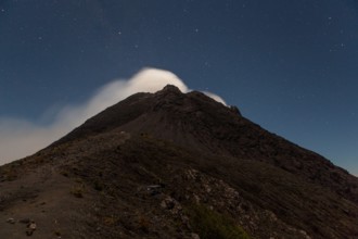Smoke from Merapi volcano under stars at night.