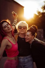 Three happy women friends at sunset, emotional portrait, friendship.