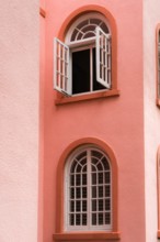 Peach colored vintage building detail exterior with arched windows and doors in the color of peach fuzz.