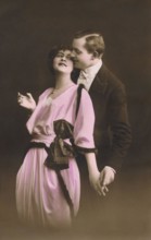 Vintage hand-coloured photograph of a romantic couple embracing. Adapted from an old postcard.