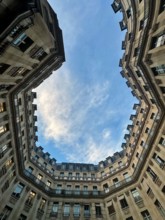 Unique perspective of the sky framed by unusual-shaped buildings in Paris – urban architecture and dramatic angles.
