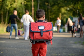 view of a child going to school with a schoolbag on his back on the first day of school in France