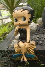 a statue of Betty Boop in a garden
