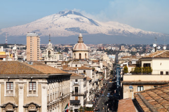 Catania, the central "Via Etnea" street with the snow covered Mount Etna volcano, Sicily, Italy