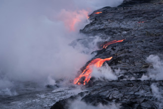 Lava from Pu'u O'o eruption entering the ocean; Hawaii Volcanoes National Park, Island of Hawaii.