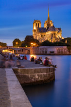 Evening on the Seine River banks in Summer with view of Notre Dame de Paris cathedral