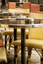 Paris sidewalk cafe classic bistro chairs and tables. Close up detail and vintage color.