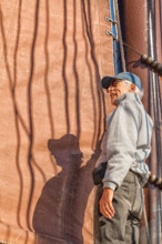 Senior man on a sailboat helps to hoist the sail. Adventure travel on a tall ship schooner. Concept for staying healthy in active retirement.