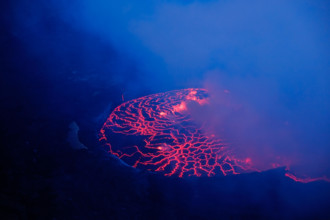 Lava and steam in crater of Nyiragongo volcano in Virunga National Park in Democratic Republic of Congo, Africa. Picture taken during dusk with blue c