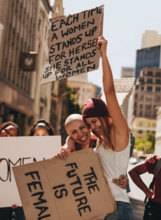 Group of young female activists protesting with signboards on road. Women enjoying during a demonstration on road.