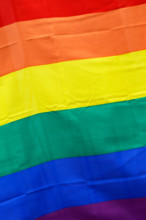 Close-up of a flag with rainbow pattern.