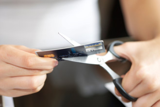 hands of female cutting a bank card in two/half