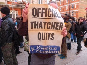 London, UK. 8th April 2013 A man holds up an Evening Standard poster which was apprently from November 1990. It said Official: Thatcher Quits. Credit: nelson pereira / Alamy Live News