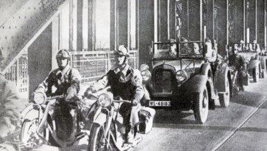 Black and white photo of the German troops crossing the Rhine River in cars and on motorcycles to enter Cologne, March 1936.