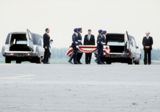 Air Force pallbearers carry a coffin containing the remains of a crew member from the space shuttle Challenger to the back of a hearse. The Challenger exploded shortly after takeoff on January 28, 198...