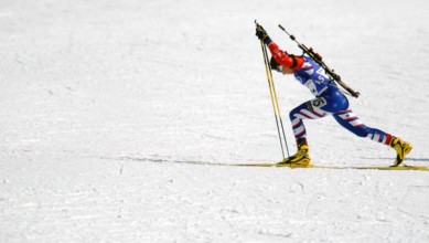 Competing in the Biathlon event, World class athlete Sergeant Kristina Sabasteanski, USA, keeps limber, with her .22 caliber, bolt-action rifle slung on her back, before her leg of the women's 4 X 7.5...