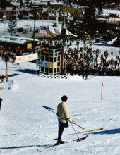 1960 Winter Olympics in Squaw Valley California: One legged skier watching skiers on the slalom course