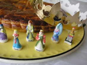 French galette des rois cake with small figurines and a crown to celebrate Epiphany in France