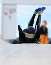 A skeleton racer dives down a track