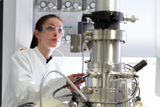 a woman scientist works in a optical lab with a SEM