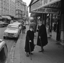 Pariser Bilder [The street life of Paris] Description: Elderly women in front of a store with meat and poultry in the Rue Lepic Date: 1965 Location: France, Paris Keywords: elderly, street sculptures,...
