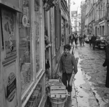 Pariser Bilder [The street life of Paris]  Boy with baguette Date: 1965 Location: France, Paris Keywords: groceries, bread, children, street images