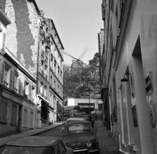 Pariser Bilder [The street life of Paris]  Rue Lepic Tholoze in Montmartre, with at the end of the street the Moulin de la Galette Date: 1965 Location: France, Paris Keywords: windmills, street images