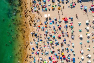 Drone shot of many people enjoying the beach and the ocean - vacation pattern. Rocha Beach in Portimao, Portugal
