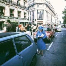 Traffic policeman checks parked cars, Paris; France, 1978