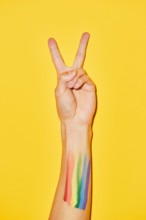Vibrant shot of arm with rainbow flag tattoo and V symbol for pride month LGBTQ