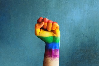 Raised rainbow fist of a man for PRIDE month and the LGBTQIA+ movement. Pride day for sexuality freedom, love diversity celebration and the fight for
